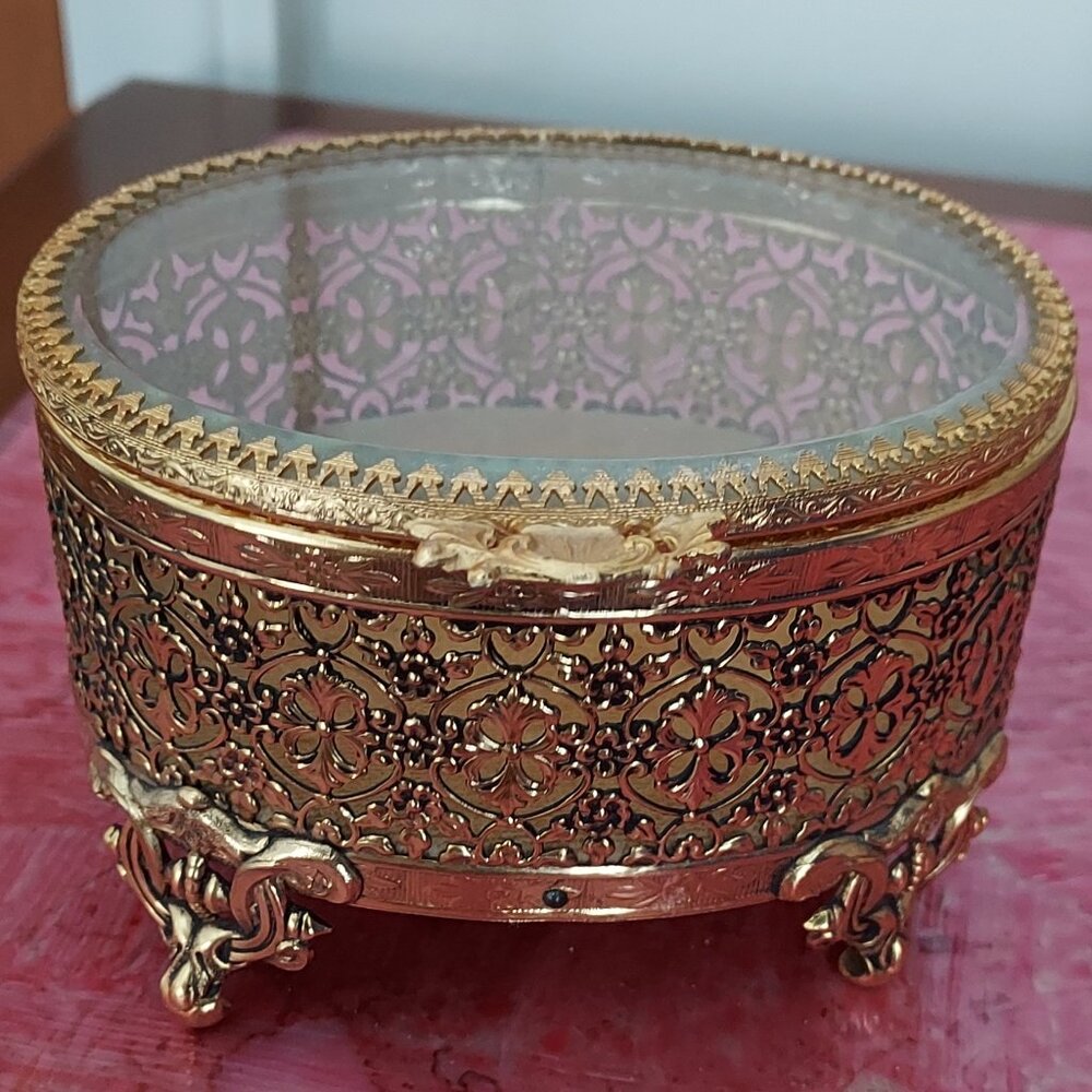 Vtg Oval Gold Tone Filigree Ormolu Footed Jewelry Box w/ Clear Glass Hinged Top